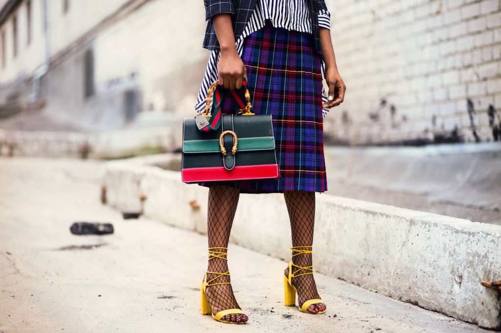 A woman wearing well chosen fashionable clothes, shoes and a bag.